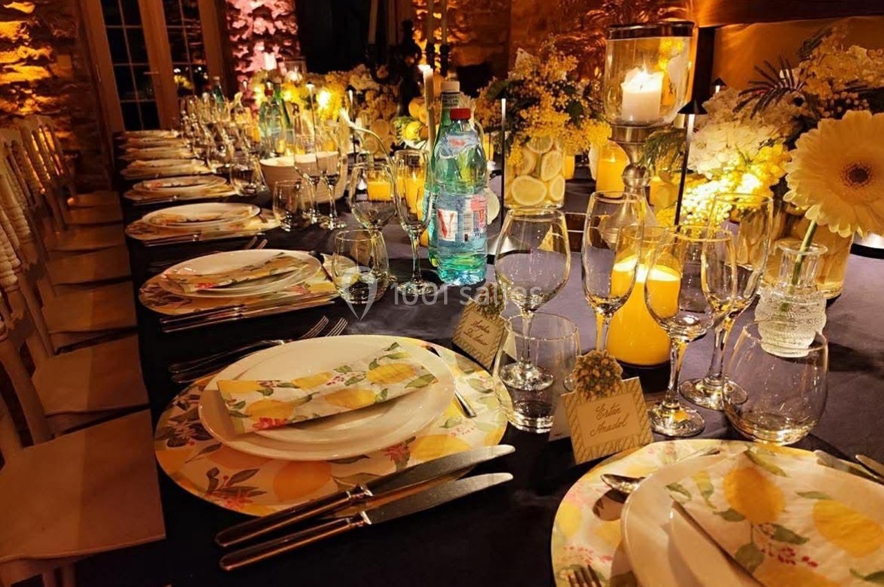 Table élégamment dressée avec vaisselle colorée, bougies, fleurs et décorations sur le thème des citrons.