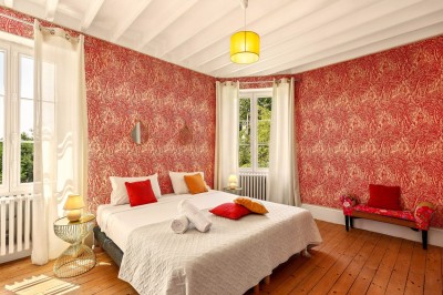 Miniature Location salle Villecerf (Seine-et-Marne) - Maison Nelson #35 Chambre lumineuse avec lit double, parquet en bois, commode, fenêtres et puits de lumière donnant sur un extérieur verdoyant.