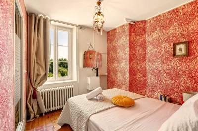 Miniature Location salle Villecerf (Seine-et-Marne) - Maison Nelson #40 Chambre lumineuse avec lit double, parquet en bois, commode, fenêtres et puits de lumière donnant sur un extérieur verdoyant.