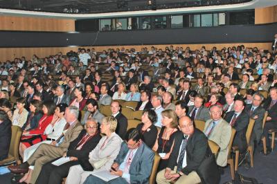 Un groupe d'adultes posant en extérieur sur une pelouse verte, avec un arbre en arrière-plan.