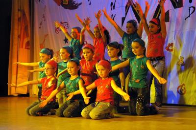 Un groupe d'adultes posant en extérieur sur une pelouse verte, avec un arbre en arrière-plan.