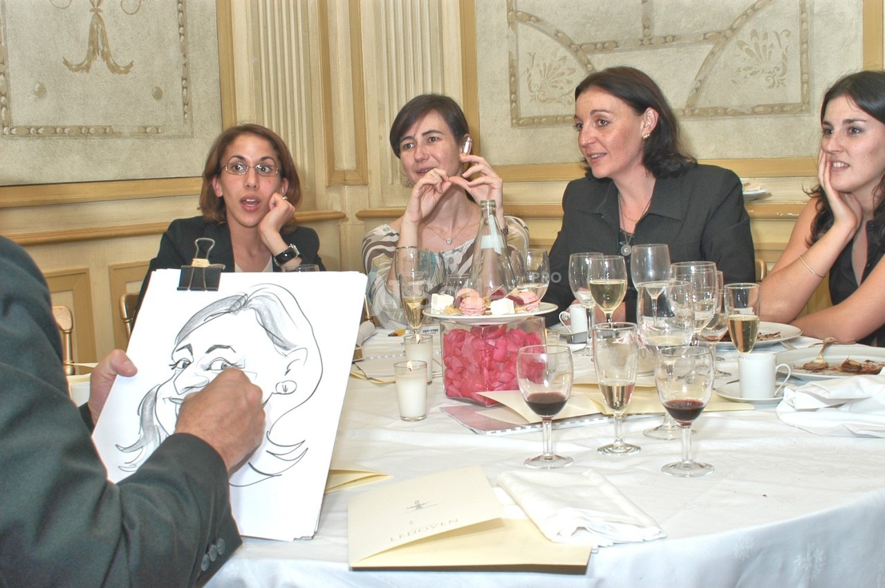 Un caricaturiste dessine une femme assise à une table avec d'autres personnes dans un cadre élégant.
