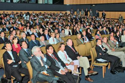 Un groupe d'adultes posant en extérieur sur une pelouse verte, avec un arbre en arrière-plan.