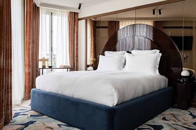 Salle de bain luxueuse avec un plan de travail en marbre vert, miroir encadré, produits de toilette et éclairage mural.