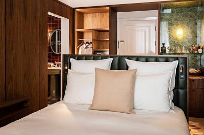 Salle de bain luxueuse avec un plan de travail en marbre vert, miroir encadré, produits de toilette et éclairage mural.