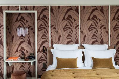 Salle de bain luxueuse avec un plan de travail en marbre vert, miroir encadré, produits de toilette et éclairage mural.