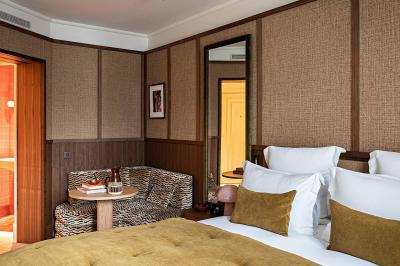 Salle de bain luxueuse avec un plan de travail en marbre vert, miroir encadré, produits de toilette et éclairage mural.