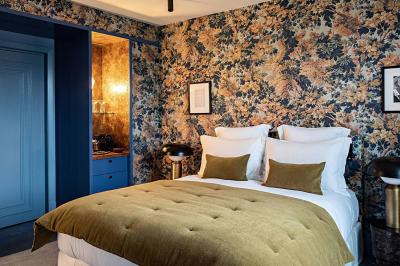 Salle de bain luxueuse avec un plan de travail en marbre vert, miroir encadré, produits de toilette et éclairage mural.