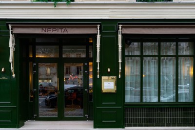 Salle de bain luxueuse avec un plan de travail en marbre vert, miroir encadré, produits de toilette et éclairage mural.
