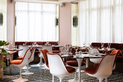 Salle de bain luxueuse avec un plan de travail en marbre vert, miroir encadré, produits de toilette et éclairage mural.