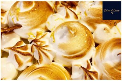 Assiette de beignets dorés disposés en cercle sur une table, avec un serveur en arrière-plan.