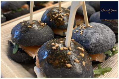 Assiette de beignets dorés disposés en cercle sur une table, avec un serveur en arrière-plan.