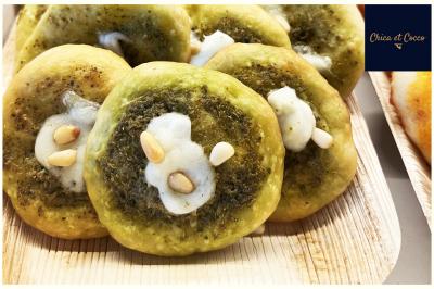 Assiette de beignets dorés disposés en cercle sur une table, avec un serveur en arrière-plan.