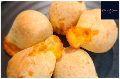 Assiette de beignets dorés disposés en cercle sur une table, avec un serveur en arrière-plan.