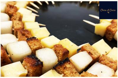 Assiette de beignets dorés disposés en cercle sur une table, avec un serveur en arrière-plan.