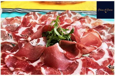 Assiette de beignets dorés disposés en cercle sur une table, avec un serveur en arrière-plan.