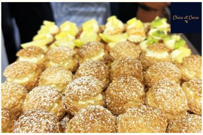 Assiette de beignets dorés disposés en cercle sur une table, avec un serveur en arrière-plan.