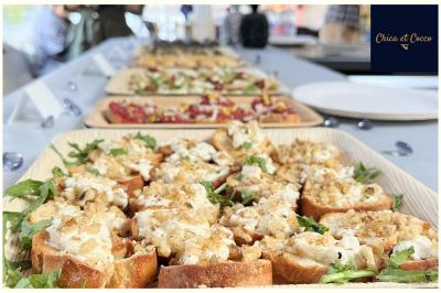 Assiette de beignets dorés disposés en cercle sur une table, avec un serveur en arrière-plan.
