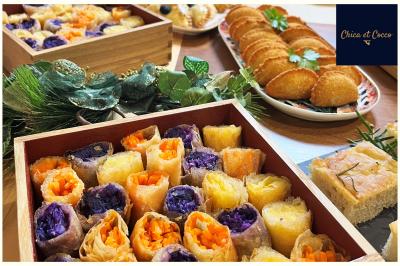 Assiette de beignets dorés disposés en cercle sur une table, avec un serveur en arrière-plan.