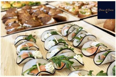 Assiette de beignets dorés disposés en cercle sur une table, avec un serveur en arrière-plan.