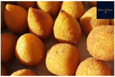 Assiette de beignets dorés disposés en cercle sur une table, avec un serveur en arrière-plan.