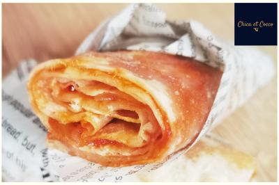 Assiette de beignets dorés disposés en cercle sur une table, avec un serveur en arrière-plan.