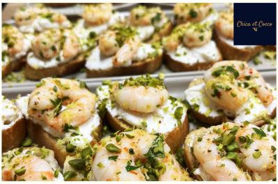 Assiette de beignets dorés disposés en cercle sur une table, avec un serveur en arrière-plan.