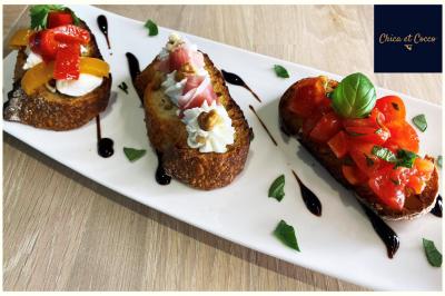 Assiette de beignets dorés disposés en cercle sur une table, avec un serveur en arrière-plan.
