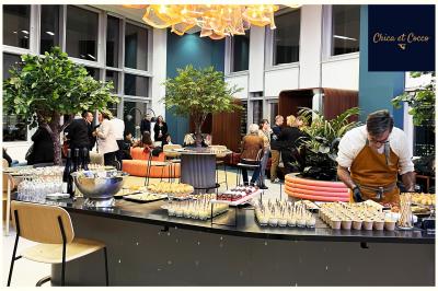 Assiette de beignets dorés disposés en cercle sur une table, avec un serveur en arrière-plan.