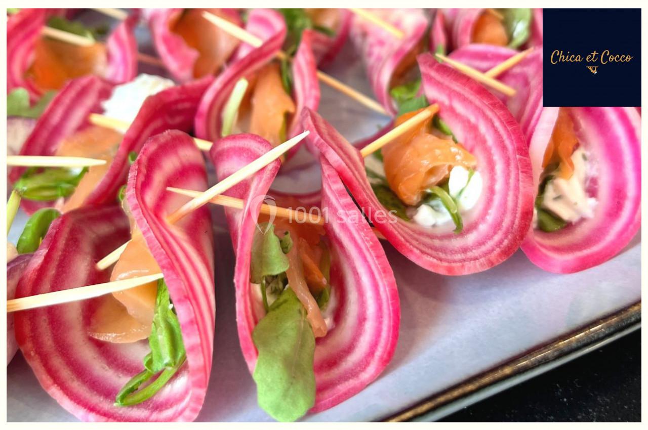 Tranches de betterave chioggia garnies de saumon fumé, fromage frais et roquette, maintenues par des piques en bois.