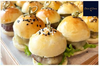 Miniature Traiteur Saint-Germain-en-Laye (Yvelines) - Chica et Cocco #13 Assiette garnie de beignets dorés en forme de demi-lune, présentée sur une table avec une coupe en arrière-plan.