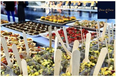 Miniature Traiteur Saint-Germain-en-Laye (Yvelines) - Chica et Cocco #23 Assiette garnie de beignets dorés en forme de demi-lune, présentée sur une table avec une coupe en arrière-plan.