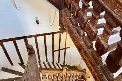 Miniature Au sein des gîtes : l'escalier Louis XIII d'accès aux chambres Ruines éclairées et bâtiment adjacent sous un ciel nocturne, avec un arbre illuminé et des bancs sur une pelouse.