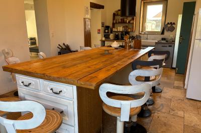 Miniature Au sein des gîtes : la cuisine Ruines éclairées et bâtiment adjacent sous un ciel nocturne, avec un arbre illuminé et des bancs sur une pelouse.