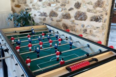 Miniature Au sein des gîtes : le babyfoot Ruines éclairées et bâtiment adjacent sous un ciel nocturne, avec un arbre illuminé et des bancs sur une pelouse.