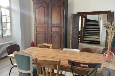 Miniature Au sein des gîtes : le grand salon Ruines éclairées et bâtiment adjacent sous un ciel nocturne, avec un arbre illuminé et des bancs sur une pelouse.