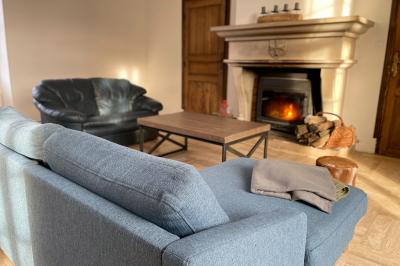 Miniature Au sein des gîtes : le grand salon Ruines éclairées et bâtiment adjacent sous un ciel nocturne, avec un arbre illuminé et des bancs sur une pelouse.