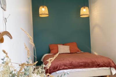 Miniature Au sein des gîtes : les chambres Ruines éclairées et bâtiment adjacent sous un ciel nocturne, avec un arbre illuminé et des bancs sur une pelouse.