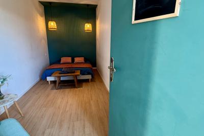 Miniature Au sein des gîtes : les chambres Ruines éclairées et bâtiment adjacent sous un ciel nocturne, avec un arbre illuminé et des bancs sur une pelouse.