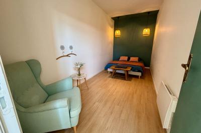 Miniature Au sein des gîtes : les chambres Ruines éclairées et bâtiment adjacent sous un ciel nocturne, avec un arbre illuminé et des bancs sur une pelouse.