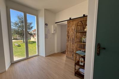 Miniature Au sein des gîtes : lieu de passage Ruines éclairées et bâtiment adjacent sous un ciel nocturne, avec un arbre illuminé et des bancs sur une pelouse.