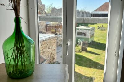 Miniature Au sein des gîtes : lieu de passage Ruines éclairées et bâtiment adjacent sous un ciel nocturne, avec un arbre illuminé et des bancs sur une pelouse.