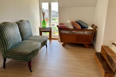 Miniature Au sein des gîtes : lieu de passage Ruines éclairées et bâtiment adjacent sous un ciel nocturne, avec un arbre illuminé et des bancs sur une pelouse.