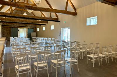 Miniature Grande salle de réception (1ere partie charpente apparente) en mode séminaire Ruines éclairées et bâtiment adjacent sous un ciel nocturne, avec un arbre illuminé et des bancs sur une pelouse.