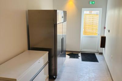 Miniature Grande salle de réception : l'arrière cuisine Ruines éclairées et bâtiment adjacent sous un ciel nocturne, avec un arbre illuminé et des bancs sur une pelouse.