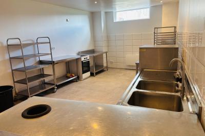 Miniature Grande salle de réception : la cuisine semi traiteur Ruines éclairées et bâtiment adjacent sous un ciel nocturne, avec un arbre illuminé et des bancs sur une pelouse.