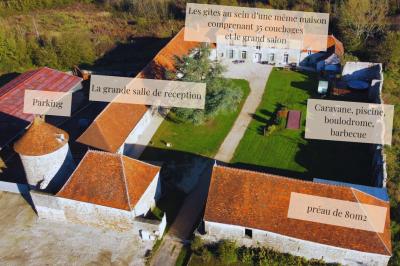 Miniature Plan du Domaine Ruines éclairées et bâtiment adjacent sous un ciel nocturne, avec un arbre illuminé et des bancs sur une pelouse.