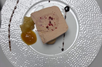 Miniature Traiteur Navarrenx (Pyrénées-Atlantiques) - Maison K Traiteur Event #49 Bloc de préparation alimentaire enrobé d'une couche jaune, posé sur une planche noire sur une surface métallique.