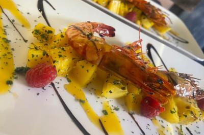 Assiettes composées de steaks grillés, purée, groseilles rouges, salade verte garnie de fleurs comestibles et sauce.