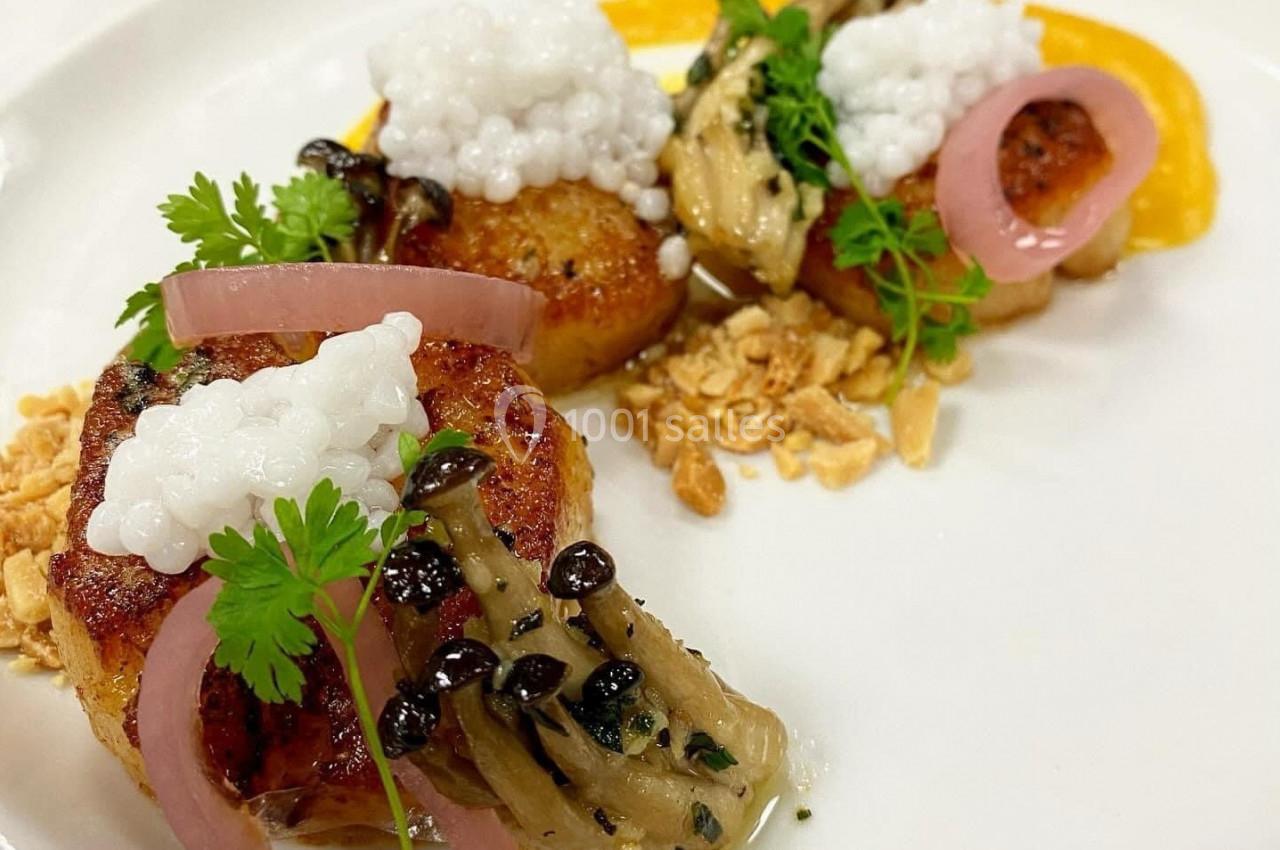 Assiette gastronomique avec noix de Saint-Jacques, champignons, pickles d'oignons, perles de tapioca et herbes fraîches.